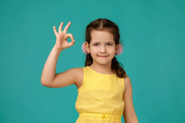 Милая улыбающаяся маленькая девочка делает ОК жест — стоковое фото
