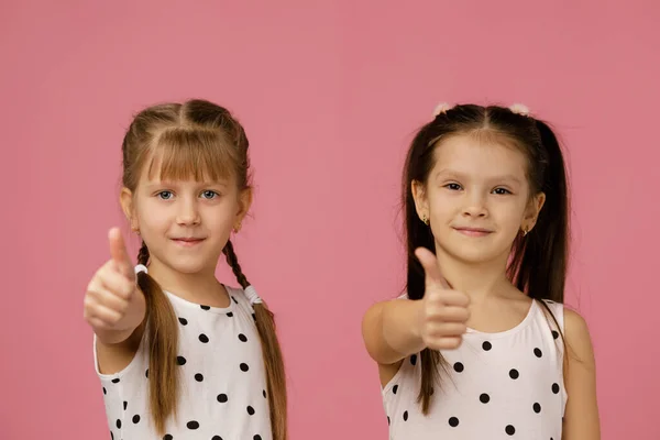 Twee gelukkig mooi klein kind meisjes tonen duimen omhoog — Stockfoto
