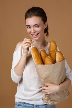 Genç bir kadın ekmek tutuyor.