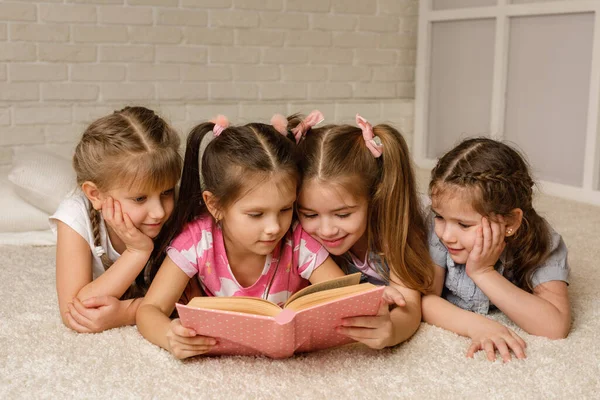 Groep van kind gaan liggen op de vloer en het lezen van het verhaal boek — Stockfoto