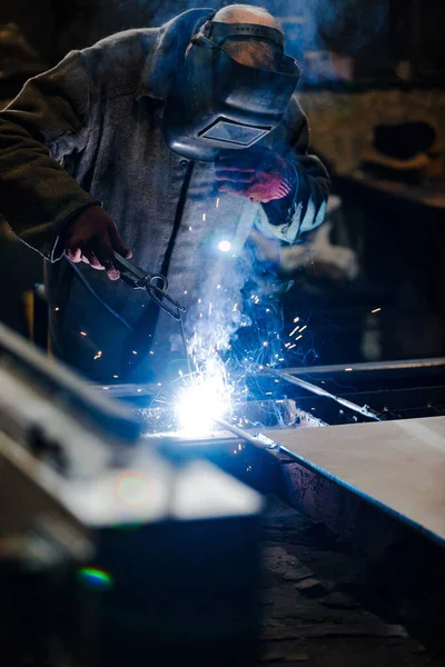 Trabajador en uniforme protector y máscara de soldadura de metal . — Foto de Stock