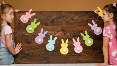 İki küçük mutlu kız ellerinde tahta tutuyorlar.