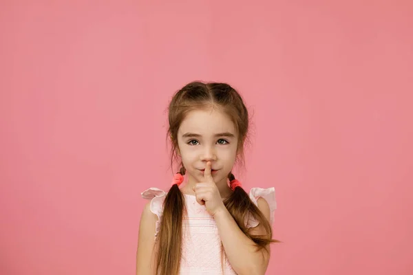 Schönes kleines Mädchen, das mit dem Finger auf den Lippen um Ruhe bittet — Stockfoto