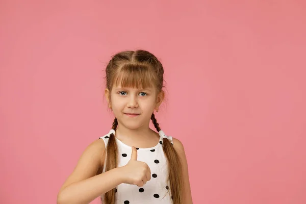 Niña en vestido mostrando los pulgares hacia arriba — Foto de Stock