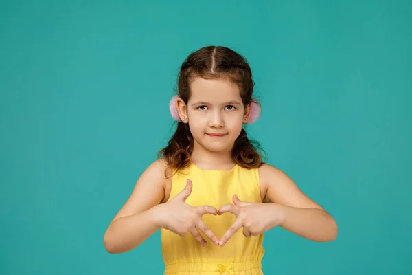 Petite fille souriante mignonne faisant un geste en forme de cœur — Photo