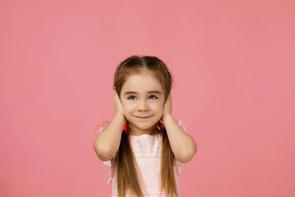 Klein kind meisje bedekken haar oor met haar hand. — Stockfoto