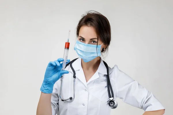 Woman doctor in mask and rubber gloves holding syringe — Stockfoto