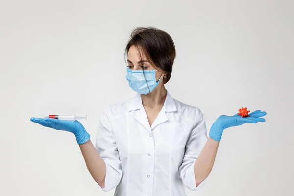 Mujer médico sosteniendo jeringa y modelo de virus — Foto de Stock