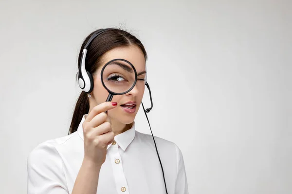 Női tanácsadó a call center a fejhallgató gazdaság nagyító üveg — Stock Fotó