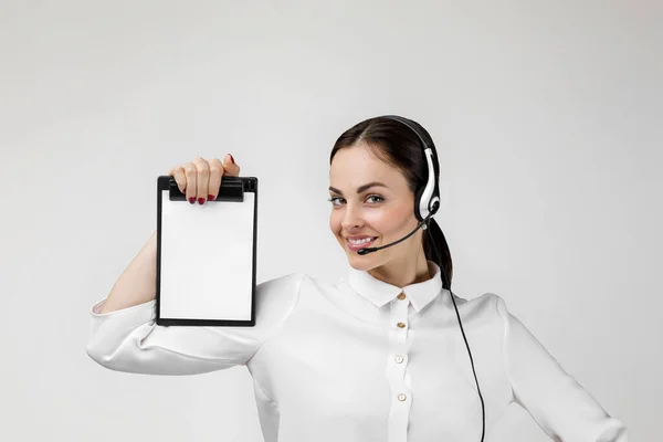 Consultant of call center in headphones holding clipboard — Zdjęcie stockowe