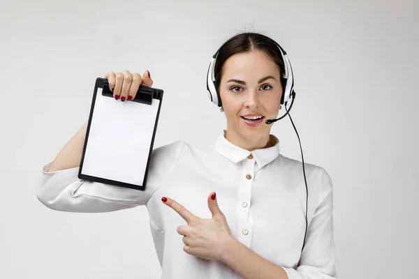 Consultant of call center in headphones holding clipboard — Stockfoto