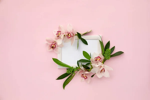 Photo frame decorated with green leaves and orchid flowers — Stock Photo, Image