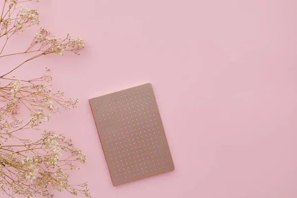 Επίπεδα λουλούδια θέσει και ένα ημερολόγιο σε ροζ φόντο, πάνω άποψη. μακιγιάρισμα — Φωτογραφία Αρχείου