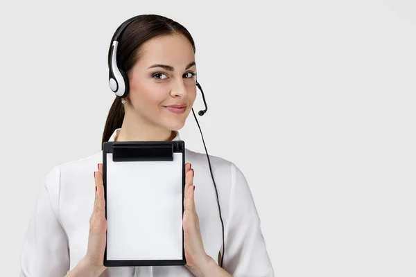 Consultant of call center in headphones holding clipboard — Stockfoto