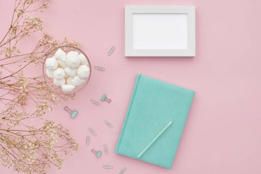 Düz çiçekler ve pembe arka planda bir günlük, üst manzara. maket yap