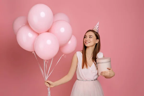 Жінка в капелюсі на день народження святкує з пастельними рожевими повітряними кулями — стокове фото