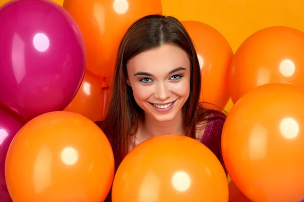 Sonriente chica caucásica posando con globos de aire de color brillante — Foto de Stock