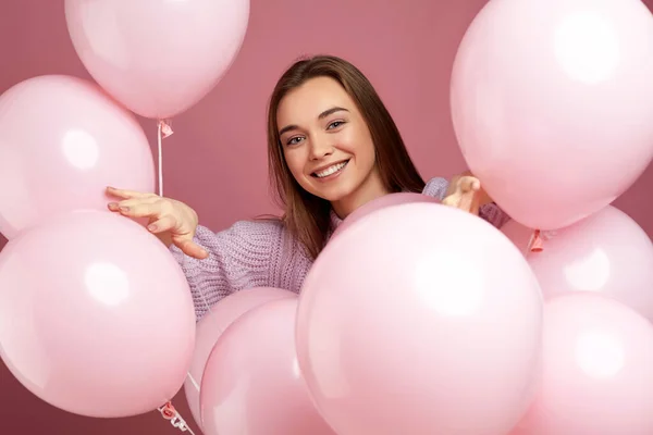 Дівчина позує з пастельними рожевими повітряними кулями — стокове фото