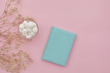 Düz çiçekler ve pembe arka planda bir günlük, üst manzara. maket yap