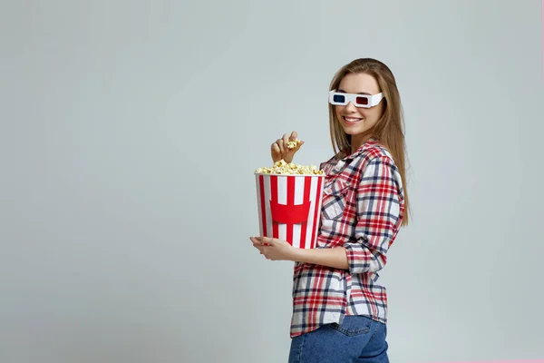 Улыбающаяся женщина в красно-синих 3d очках держит ведро попкорна — стоковое фото