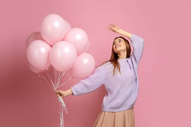 Doğum günü kızı balonlarla poz veriyor.