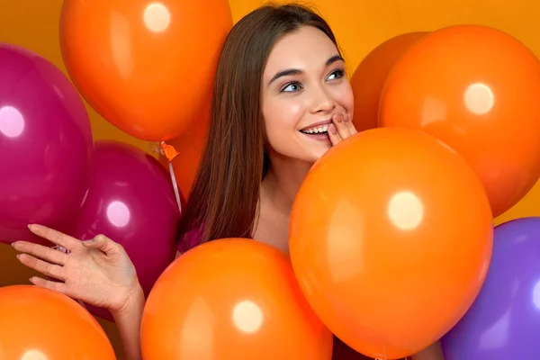 Sonriente chica caucásica posando con globos de aire de color brillante — Foto de Stock