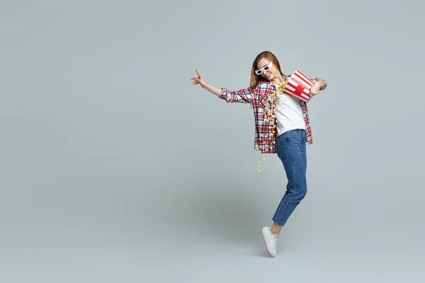 woman in red-blue 3d glasses holding bucket with popcorn