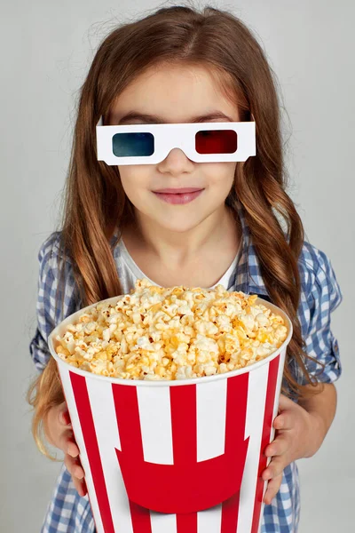 Enfant fille en rouge-bleu 3d lunettes tenant seau de maïs soufflé — Photo