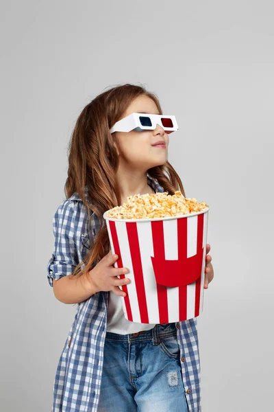 Dziecko dziewczyna w czerwono-niebieskie okulary 3d i jedzenia popcornu — Zdjęcie stockowe