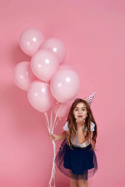 Kind meisje vieren met pastel roze lucht ballonnen — Stockfoto