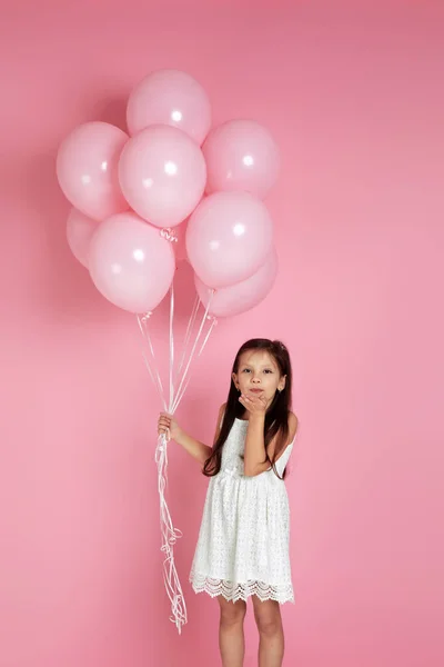 Lachend schattig klein kind meisje met pastel roze lucht ballonnen — Stockfoto