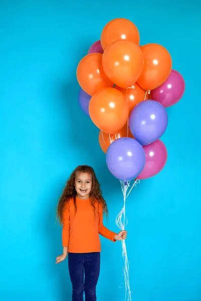 Barn flicka i rosa t-shirt poserar med ljusa färgglada luftballonger — Stockfoto