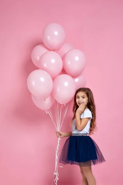 Barn flicka poserar med pastell rosa luft ballonger — Stockfoto
