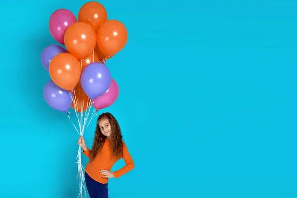 Child girl in pink t-shirt posing with bright colorful air balloons — Stock Photo, Image