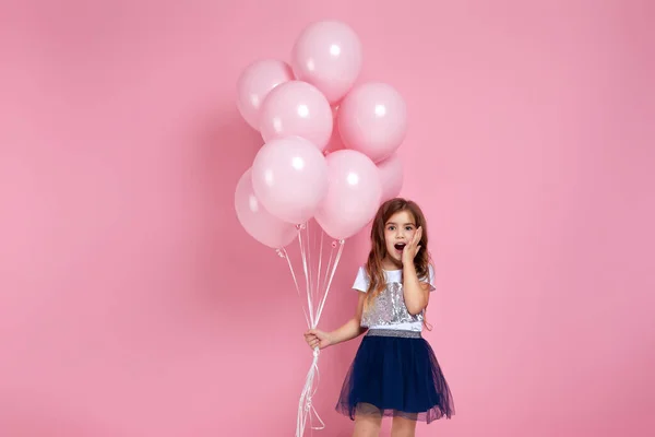 Niña posando con globos de aire de color rosa pastel — Foto de Stock