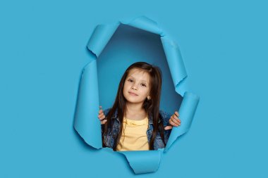 Şirin, mutlu, gülümseyen, beyaz tenli kızın portresi sıkılmış yumruklarını kaldırıyor.