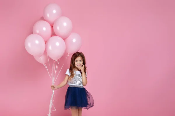 Kind meisje poseren met pastel roze lucht ballonnen — Stockfoto