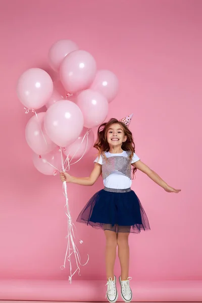 Kind meisje vieren met pastel roze lucht ballonnen — Stockfoto