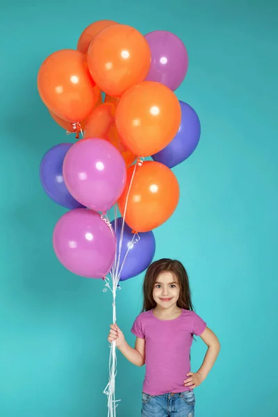 Kind meisje in roze t-shirt poseren met heldere kleurrijke lucht ballonnen — Stockfoto