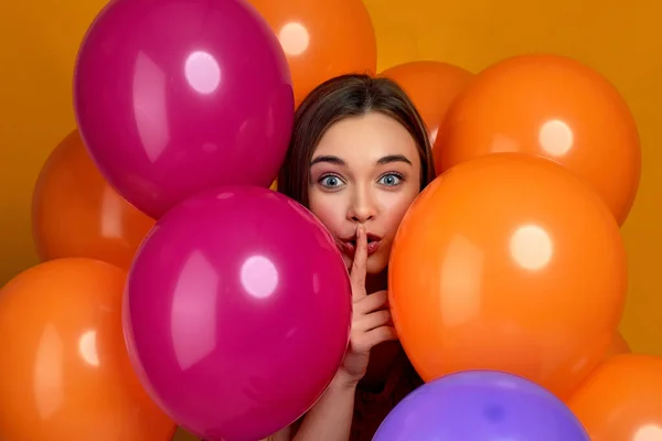 Улыбающаяся кавказская девушка позирует с воздушными шарами яркого цвета — стоковое фото