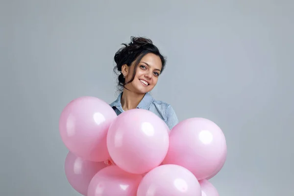 Chica en denim celebración de pastel rosa globos de aire — Foto de Stock