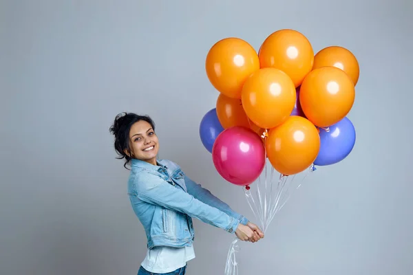 Chica en denim posando con brillantes globos de aire de colores — Foto de Stock