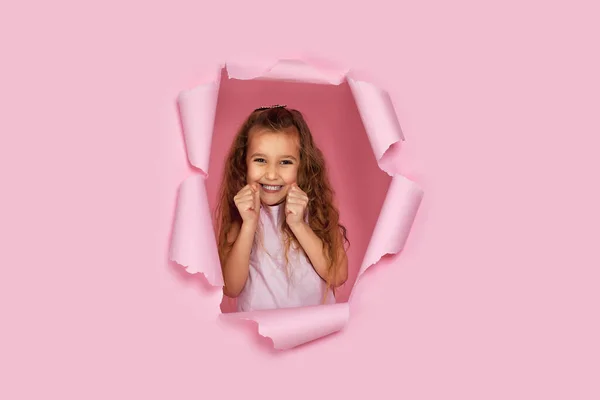 Retrato de bonito feliz sorrindo caucasiano pequena menina cild levanta punhos apertados — Fotografia de Stock