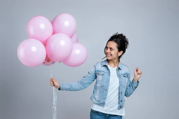 Chica en denim celebración de pastel rosa globos de aire — Foto de Stock