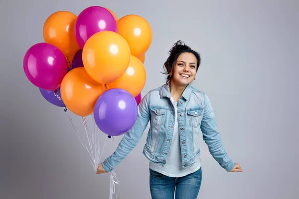 Chica en denim posando con brillantes globos de aire de colores — Foto de Stock