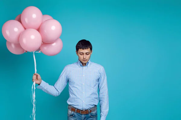 Hombre con camisa sosteniendo globos de aire rosa — Foto de Stock