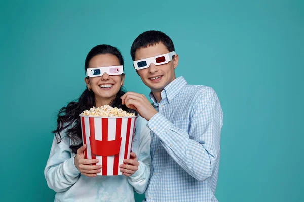 Couple en rouge-bleu 3d lunettes manger pop-corn à partir du seau — Photo