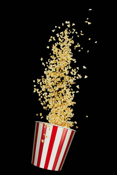 Flying popcorn from red and white paper striped bucket