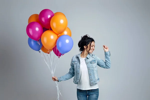 Parlak renkli hava balonlarıyla poz veren kot giyen kız. — Stok fotoğraf