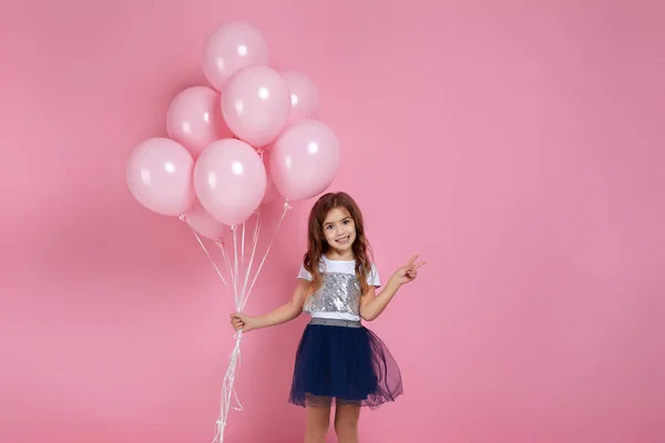 Kind meisje poseren met pastel roze lucht ballonnen — Stockfoto